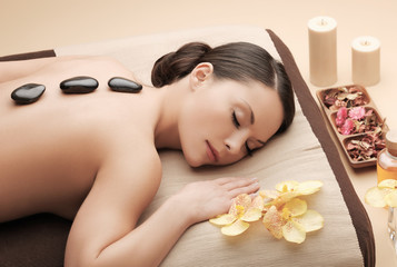 asian woman in spa with hot stones