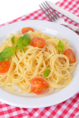 Delicious spaghetti with tomatoes on plate on table close-up
