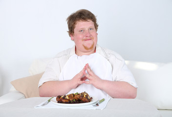 Tasty lunch for fat man, on home interior background