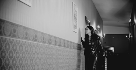 woman in black with guitar at hotel corridor