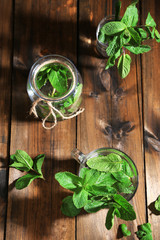 Mint in glass jar on wooden background