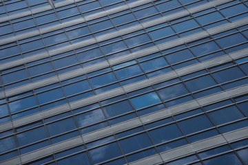 Obraz premium Reflections of clouds in blue glass skyscraper