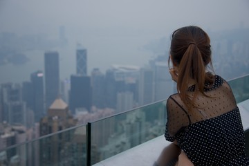 Fototapeta premium Chinese girl looking out over Victoria Harbour