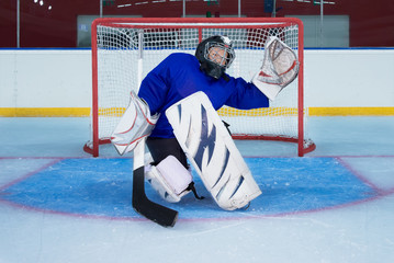 Young hockey goalie catching a flying puck