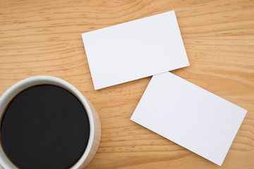 Obraz na płótnie Canvas blank business cards and coffee on wooden table