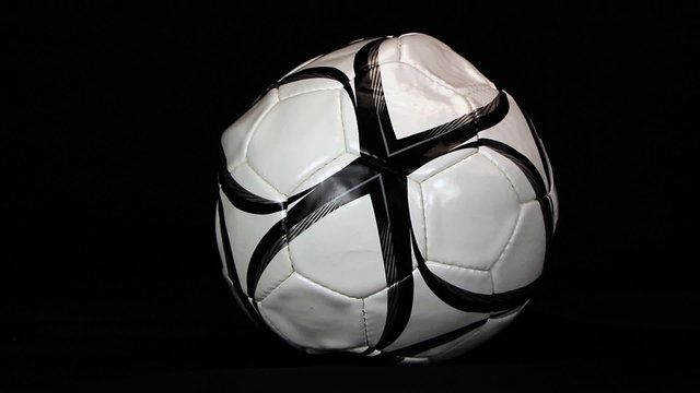 Soccer ball is inflating on a black background, close up