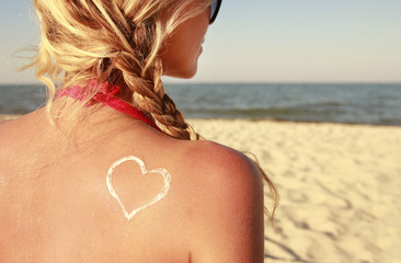 heart of the cream on the female back on the beach