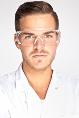 Portait of young male lab assistant with protective glasses