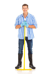 Fototapeta premium young man standing with metal garden rake