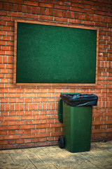 Green garbage can with plastic bag