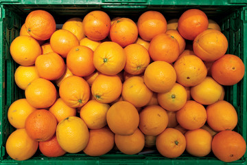 Green crate full of oranges