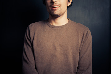 Happy young man against black background