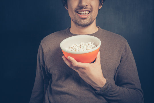 Smiling young man with popcorn