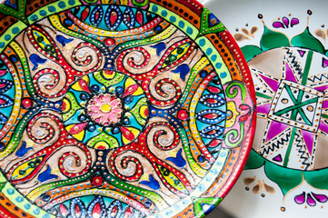 Two painted white dishes on each other.