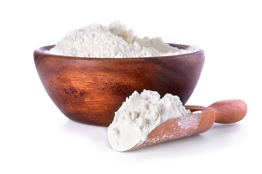 flour in a wooden bowl and shovel on a white background