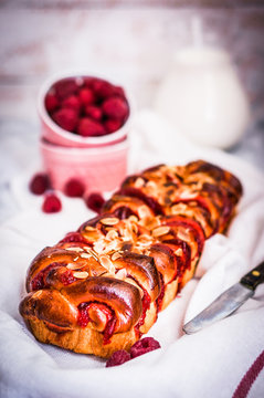 Raspberry cake with almonds on wooden background