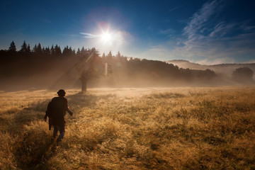 Obraz premium Photographer in forest with fog looking for adventure