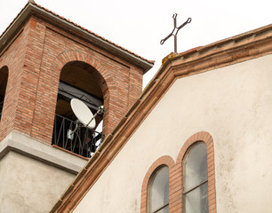 Satellite dish and cross on church