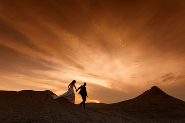 Silhouette of wedding couple with the red sunset