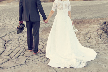Fototapeta na wymiar Wedding couple holding on trash the dress with dirty dress