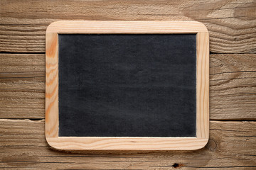 Blackboard in wooden frame on old wood