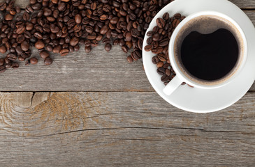 Coffee cup and beans on wooden table