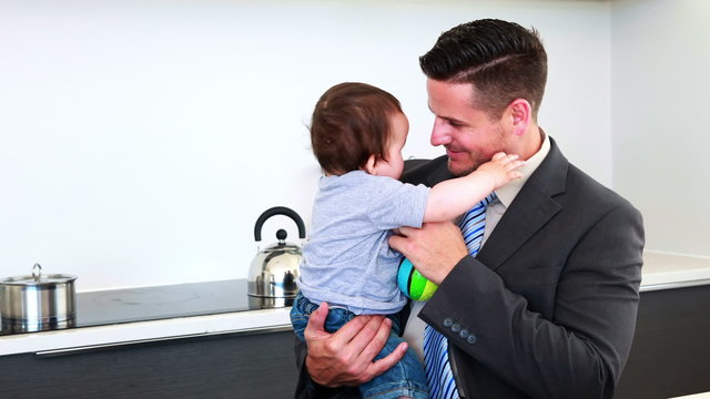 Father holding his baby son before work in the morning