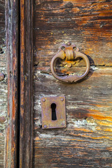 Old wooden door handle peeling and rusty iron