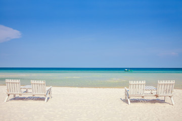 White wooden chairs on white sand beach