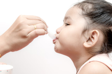 Mother giving  baby girl medicine syrup
