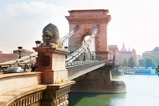 Chain bridge with monument of lion in Budapest