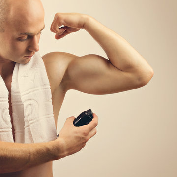 Fit Young Man Applying Antiperspirant Spray Deodorant