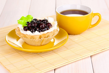sweet cake with cup of tea on wooden background