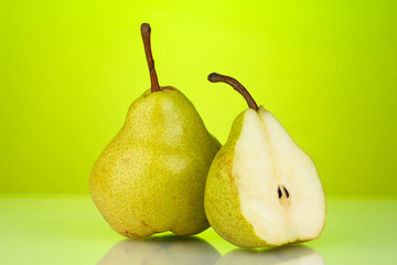 Ripe pears on bright green background