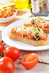 Delicious bruschetta with tomatoes on plate on table close-up