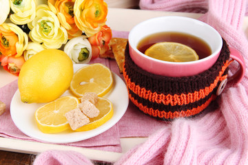 Cup of tea with lemon in scarf close up