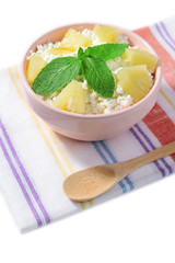 Bowl of tasty cottage cheese with pineapple, isolated on white