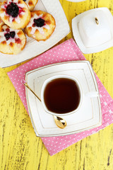 Cup of tea with sweet pastries on table close-up