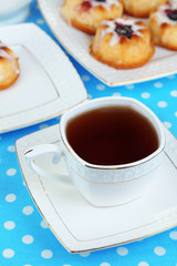 Cup of tea with sweet pastries on table close-up