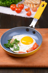 Scrambled eggs and bacon on frying pan on table close-up