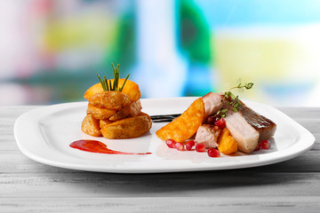 Grilled meat  with fried potato pieces and pomegranate seeds