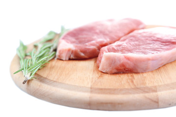 Raw meat steak with herbs on cutting board, isolated on white