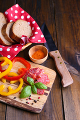 Composition with knife,  tasty salami sausage, sliced bread and