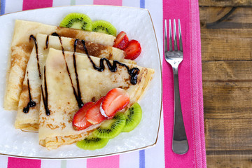 Delicious pancakes with strawberries and chocolate