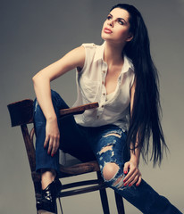 beautiful brunette, sitting on a brown wooden chair