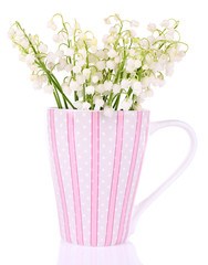 Beautiful lilies of the valley in cup, isolated on white