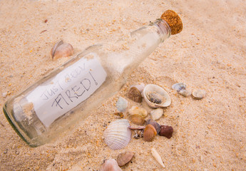 Concept image of a message JUST BEEN FIRED in a bottle
