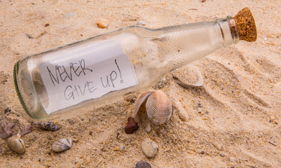 Concept image of a message NEVER GIVE UP in a bottle