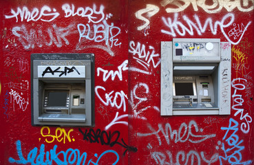 Cash machine in a graffiti red wall