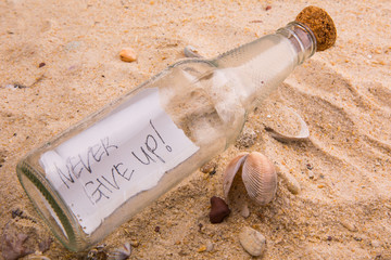 Concept image of a message NEVER GIVE UP in a bottle